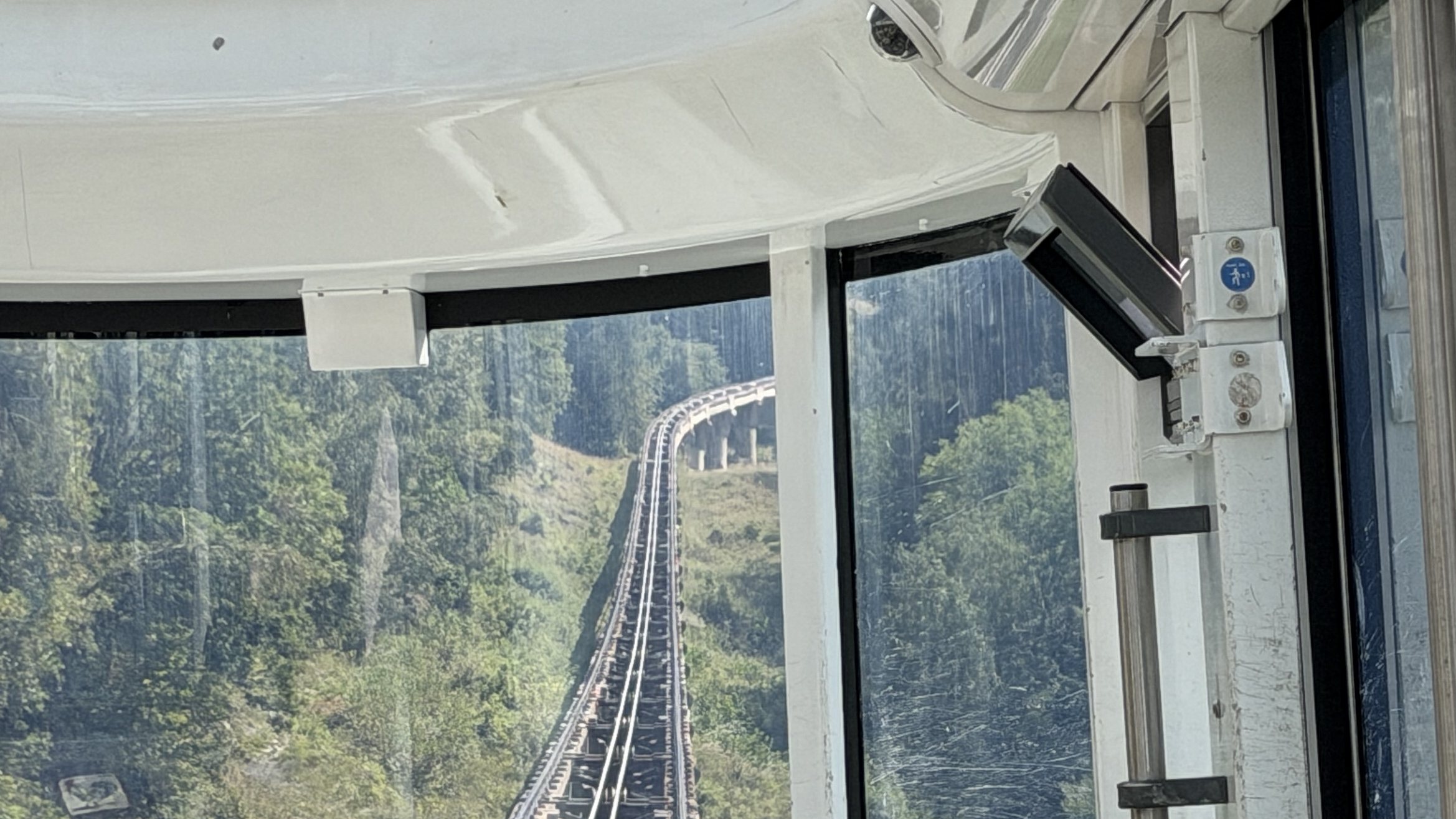 Voie du funiculaire vue depuis la cabine, montant à travers la forêt jusqu'à un viaduc