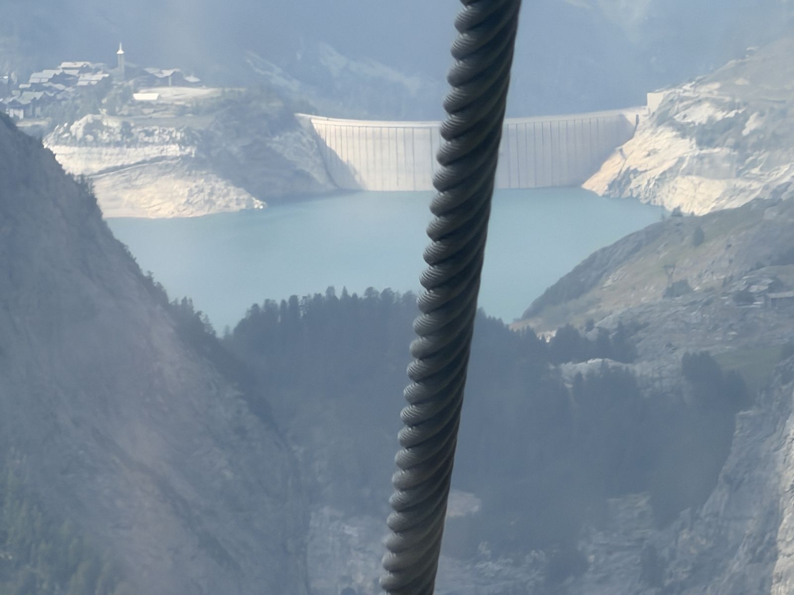 Le barrage de Tignes et le lac du Chevril vus depuis la télécabine, un câble au premier plan