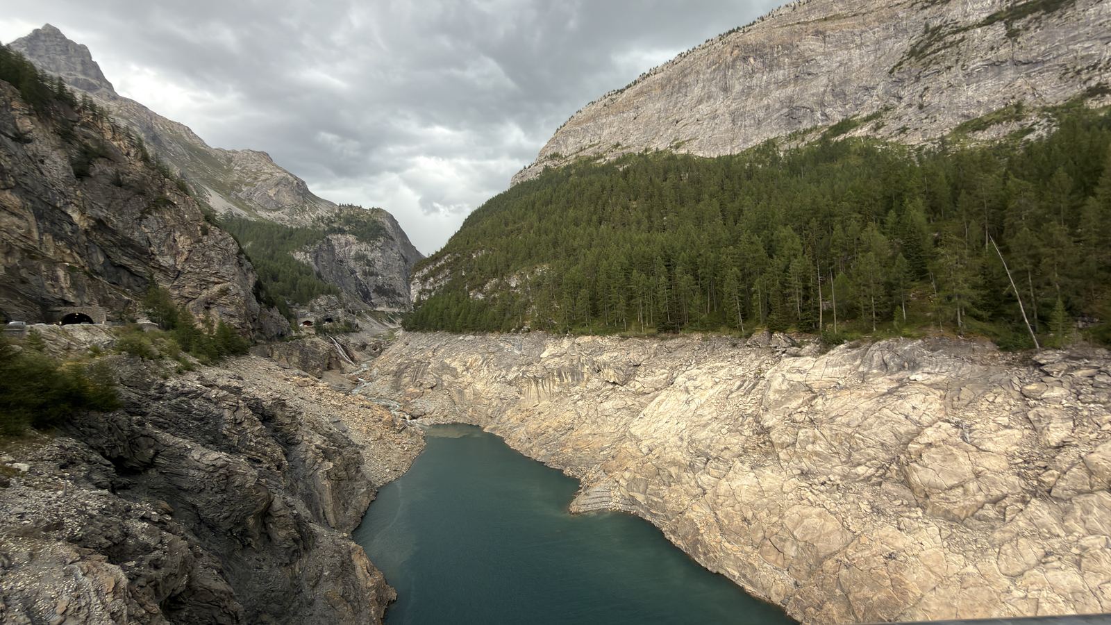 Vue depuis la passerelle himalayenne vers l'amont du lac du Chevril, retenue basse et parois décolorées