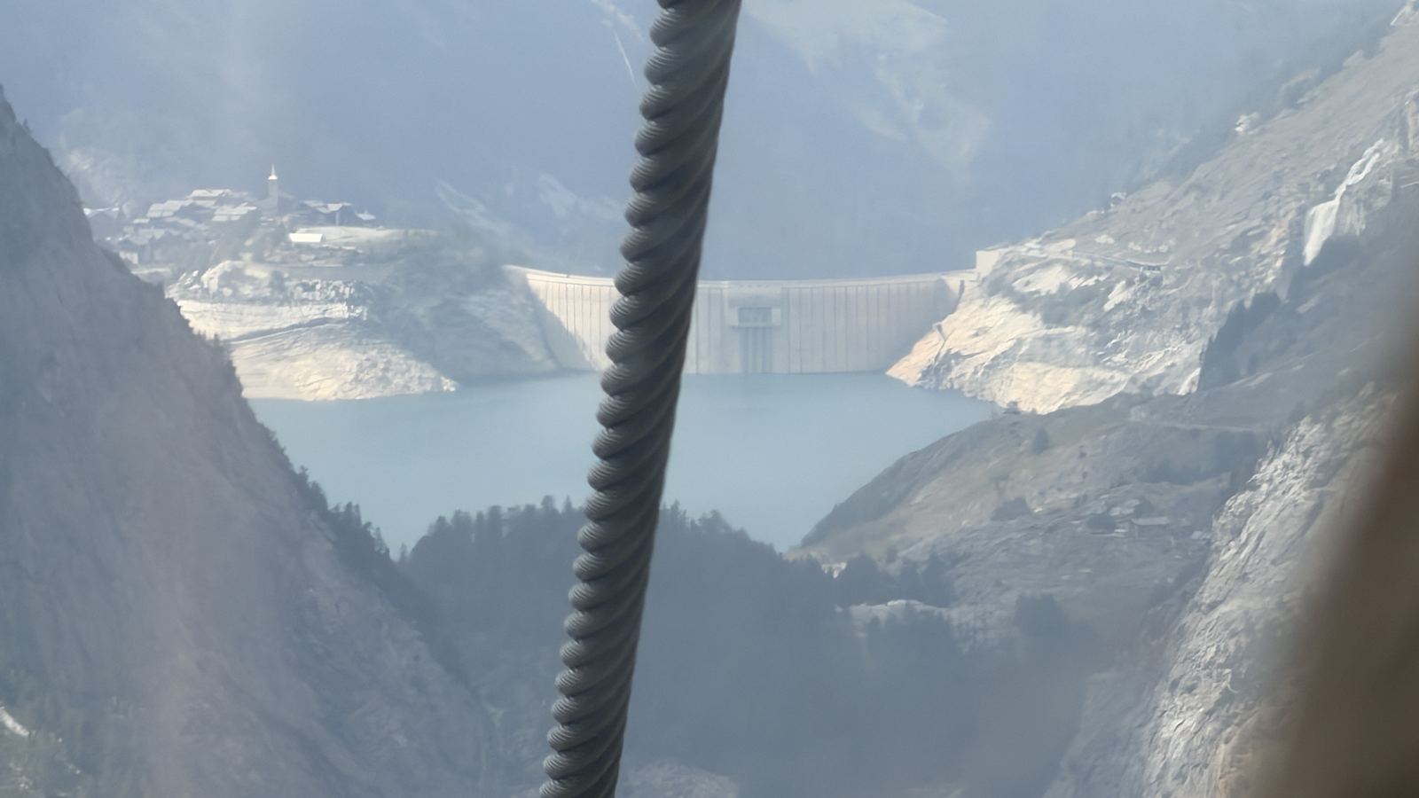 Le hameau perché au-dessus du barrage de Tignes et la retenue du Chevril, vus depuis la télécabine